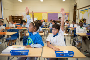 Students raise their hands in the classroom 