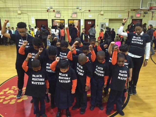 Amari, far left, with students at AF Apollo Elementary