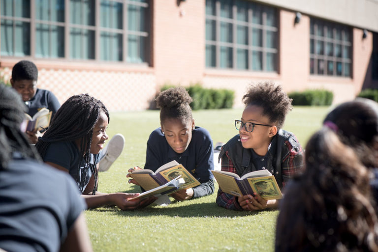 Current Amistad Academy Middle Students enjoying a day of reading on the lawn. 