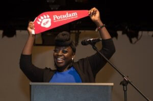 Jessica holding her college banner