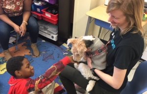 A student and teacher with a therapy dog