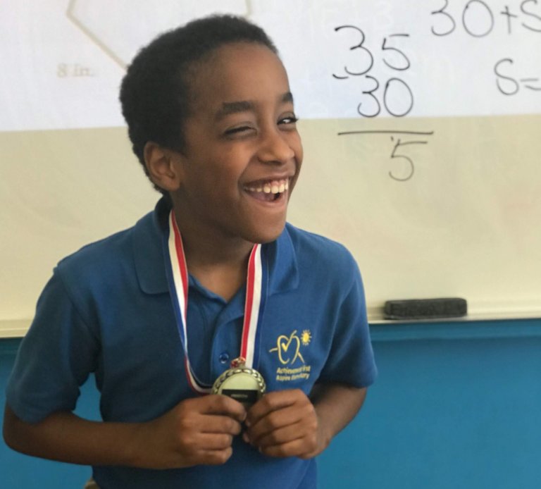Student Angel holding a medal he won