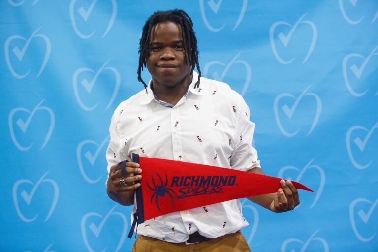 Miquell holding his college banner