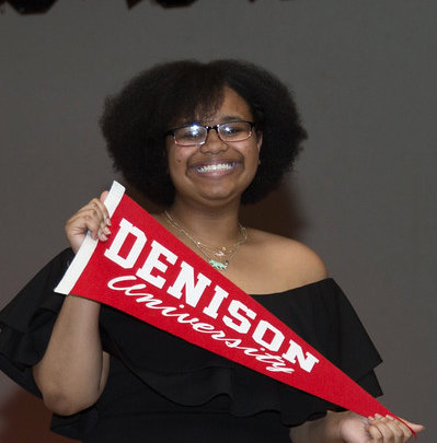 Aniah holding up her college pennant