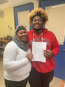 Darius and his mom holding a college acceptance