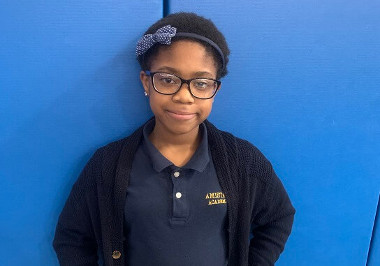 Student standing in uniform in hallway